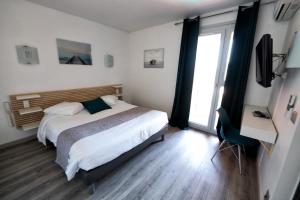 鲁西隆地区卡内阿奎瑞斯酒店的一间卧室设有一张床和一个大窗户