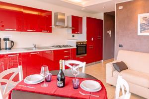 赫拉弗多纳BELLA VITA Residence的厨房配有红色橱柜和酒杯桌子