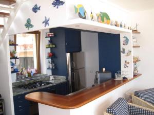 卡波利韦里Villa mit Whirlpool und phantastischer Aussicht的厨房配有柜台和冰箱。