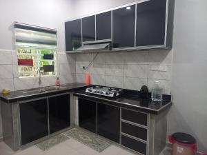 巴特沃思Yaths homestay的厨房配有黑色台面和水槽