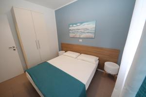 罗索利纳马雷Residence Verdena appartamento 02的一间带床和橱柜的小卧室