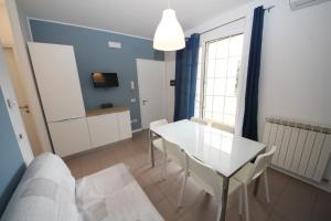 罗索利纳马雷Residence Verdena appartamento 02的客厅配有白色的桌子和椅子