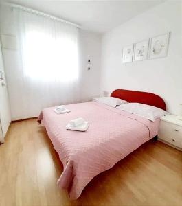 特罗吉尔Apartment Anita的一间卧室配有粉红色的床和2条毛巾