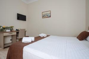巴统黛丝日落酒店的卧室配有一张白色大床和一张书桌