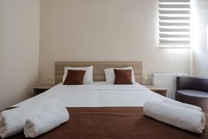 巴统黛丝日落酒店的卧室配有一张带两个枕头的大白色床