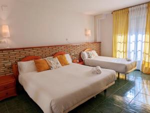 夸科斯德尤斯特莫雷贡酒店的一间卧室设有两张床和砖墙