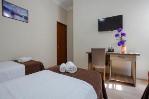 巴统黛丝日落酒店的酒店客房设有两张床、一张桌子和一台电视。