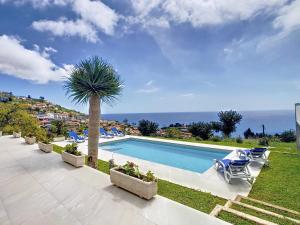 丰沙尔Avocado Villa by LovelyStay的一个带椅子的游泳池、棕榈树和大海