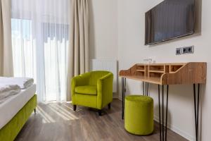于特博格Hotel Fuchsbau Jüterbog的客房设有一张床、一张桌子和一把椅子。