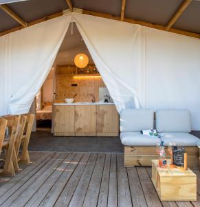 毕博纳的码头Camping Village Il Gineprino的客厅设有1个带沙发和桌子的帐篷
