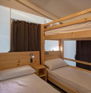 毕博纳的码头Camping Village Il Gineprino的一间卧室设有两张双层床和一扇窗户。