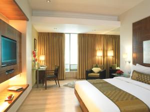 孟买丽华酒店 的酒店客房设有一张大床和一张书桌。