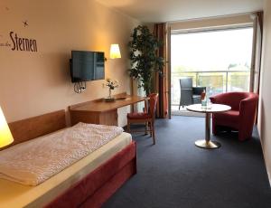 巴特申博恩哈夫纳酒店的酒店客房带一张床、一张桌子和椅子