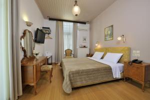 雅典德莱尔德斯猎户座酒店的一间卧室配有一张床、一张书桌和一面镜子