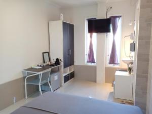 登巴萨Simple Kuta Bedroom的客房设有床、书桌和水槽