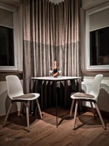 姆拉哥沃Apartament VIP PROMENADA的一张桌子、两把椅子和一张桌子及酒杯