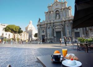 卡塔尼亚Duomo Luxury Suite Catania的餐桌,茶几,咖啡和一盘食物