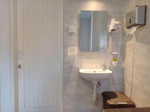 登巴萨Simple Kuta Bedroom的白色的浴室设有水槽和镜子