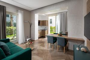 里乔内Elegance Riccione的客厅配有绿色沙发和桌子