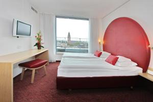 汉堡ARCOTEL Rubin Hamburg的酒店客房设有两张床、一张书桌和一个窗户。
