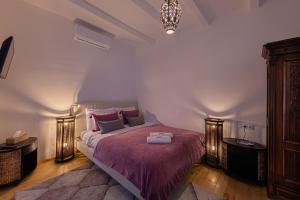 奥巴曹洛克Butik Design Nádas的一间卧室配有一张大床和紫色毯子