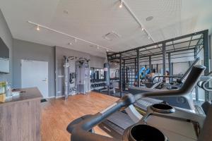 灵斯海姆FourSide Hotel Ringsheim的健身房设有两个跑步机和一个跑步机