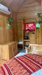 北河县Nobita Homestay bắc hà的一间设有木墙和一张地毯的床的房间