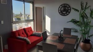 罗萨里奥Sortie - Rio的客厅配有红色的沙发和桌子