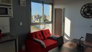 罗萨里奥Sortie - Rio的红色沙发,坐在带窗户的房间