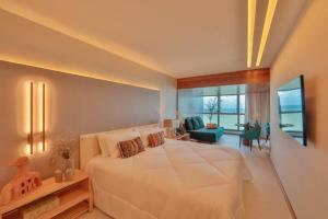 累西腓HY Apartments & Hotels的一间带白色大床的卧室和一间客厅