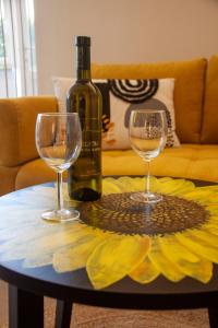 马林斯卡Apartments Katarina Porat的桌子上放有一瓶葡萄酒和两杯酒