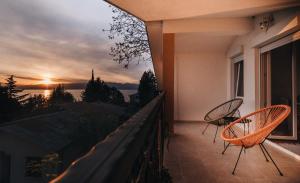 奥赫里德Villa Pandora的阳台配有两把椅子,享有日落美景