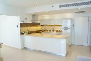荷兹利亚Daniel Hotel - Residence Seaside Luxury Flat的厨房配有白色橱柜和白色冰箱。