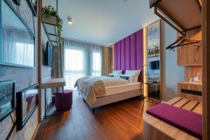 灵斯海姆FourSide Hotel Ringsheim的一间卧室配有一张床和紫色的墙壁