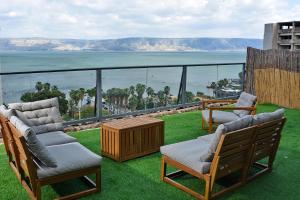 提比里亚Levication 3 bedroom lakefront的阳台配有椅子,享有海景。