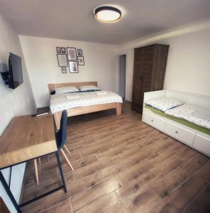 捷克克鲁姆洛夫R-膳食公寓的一间卧室配有两张床、一张桌子和一张书桌