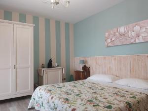 巴多利诺Poggio Bardolino的卧室配有一张床,墙上挂有绘画作品