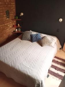 圣卡洛斯-德巴里洛切Cabaña Los Ulmos Bariloche的卧室内的一张带枕头的白色床