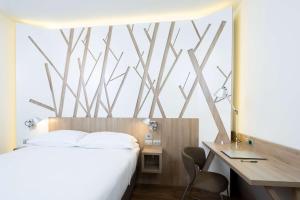 波代诺内波代诺内公园贝斯特维斯塔优质酒店的卧室配有白色的床、书桌和书桌。