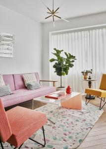 卢森堡Halcyon Days Luxembourg的客厅配有粉红色的沙发和桌子