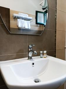 卡斯托里亚Hotel Agnanti Unique Hospitality的浴室设有白色水槽和镜子