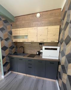 科沃拉Forest apartments的一间带木制橱柜和微波炉的厨房