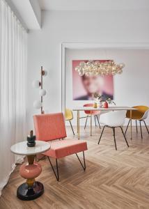 卢森堡Halcyon Days Luxembourg的一间带椅子和桌子以及吊灯的用餐室