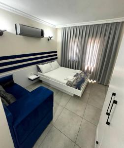 费特希耶enjoy hotel的一间卧室配有一张床和一张蓝色的沙发