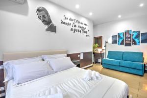 庞贝B&B Studio83 Pompei的卧室配有白色的床和蓝色的沙发