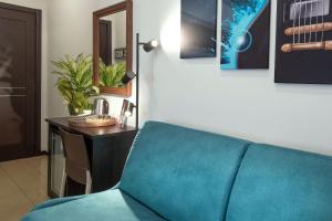 庞贝B&B Studio83 Pompei的一张蓝色沙发,坐在一张桌子上