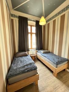 松德斯豪森Alte Post Sondershausen的一间卧室设有两张床和窗户。