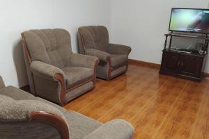Praia da GraciosaCasa dos Fenais的客厅配有两把椅子和电视