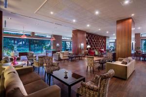 凯里尼亚Acapulco Resort Hotel的大堂配有沙发和桌椅