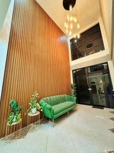 大雅台Verra Inn的大堂的绿色沙发,设有木墙